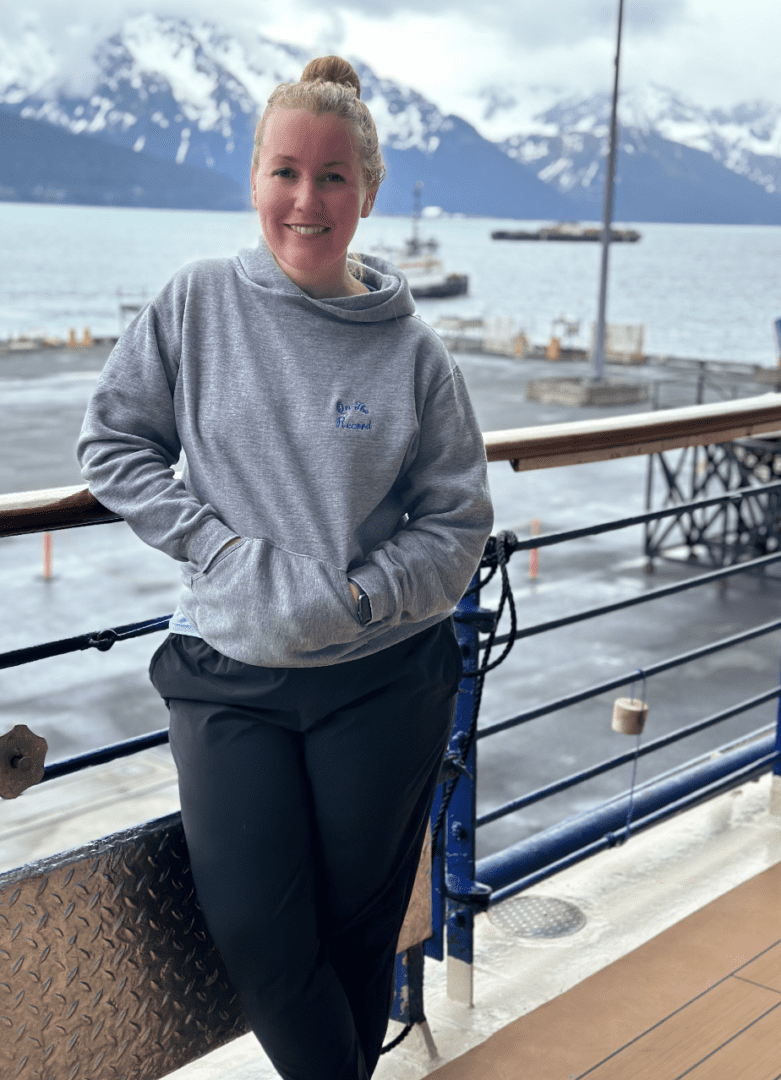 A woman standing on the side of a pier.